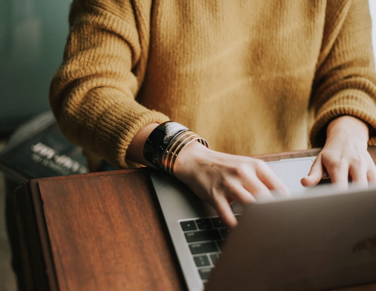 Hands typing on a laptop, refining a resume